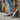 Man wearing colorful lace-ups with light denim against brick wall