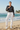 Brunette model — white linen pants, beach waves